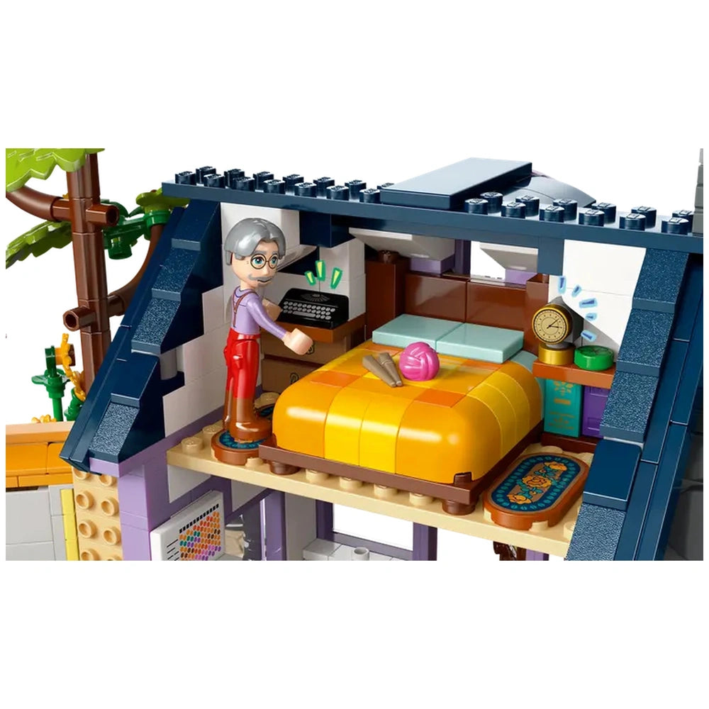 A LEGO Friends minidoll character with gray hair stands beside a colorful bed in a cozy bedroom, surrounded by vibrant décor and toys.