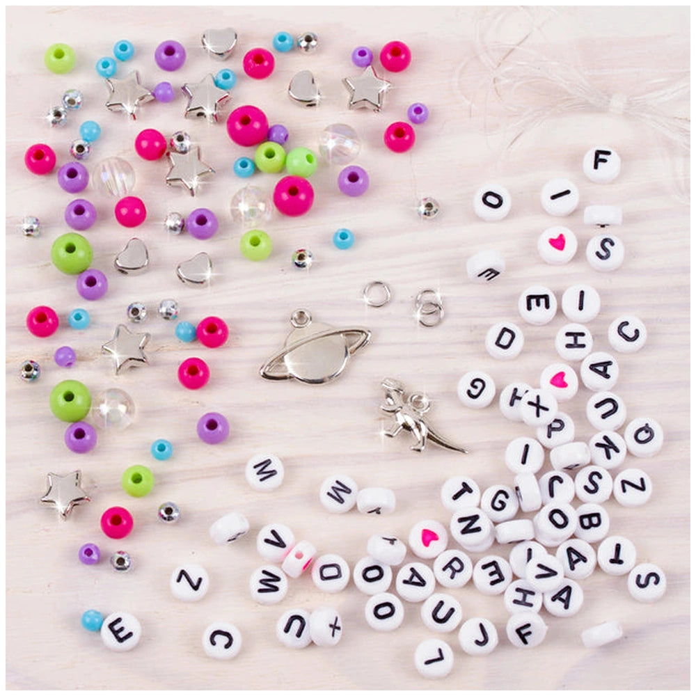 MAKE IT REAL Block ‘N’ Rock Bracelets featuring colorful beads and metal components scattered on a light surface.