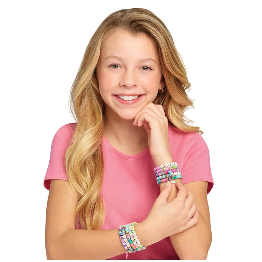 Heishi Craze Swift Clicks Beads Set displayed with a smiling girl in a pink t-shirt and multi-colored bracelets against a whi