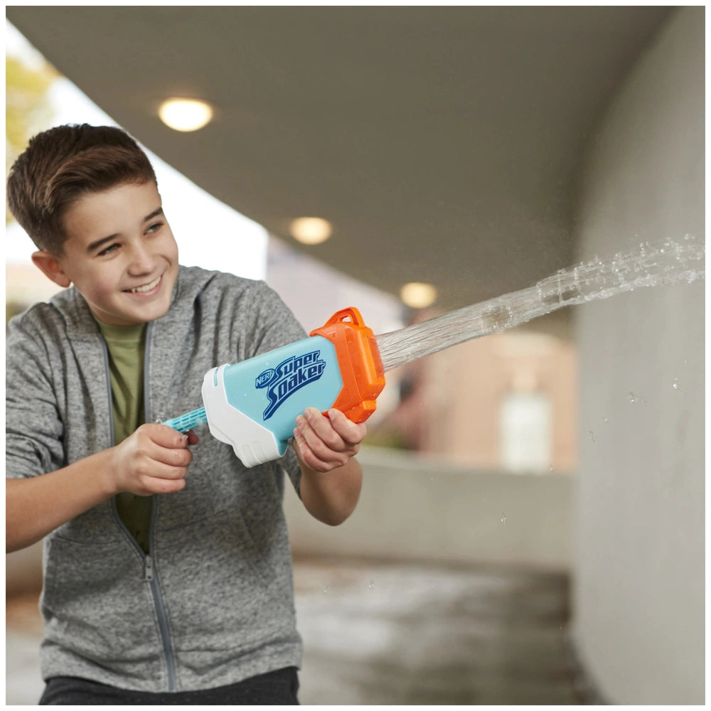 Nerf Super Soaker Torrent Water Blaster held by a boy in a gray hoodie, spraying a clear stream of water with a blue and oran
