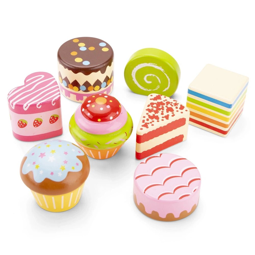 New Classic Toys cake stand set features six vibrant plastic items in pink, yellow, and green, arranged playfully.