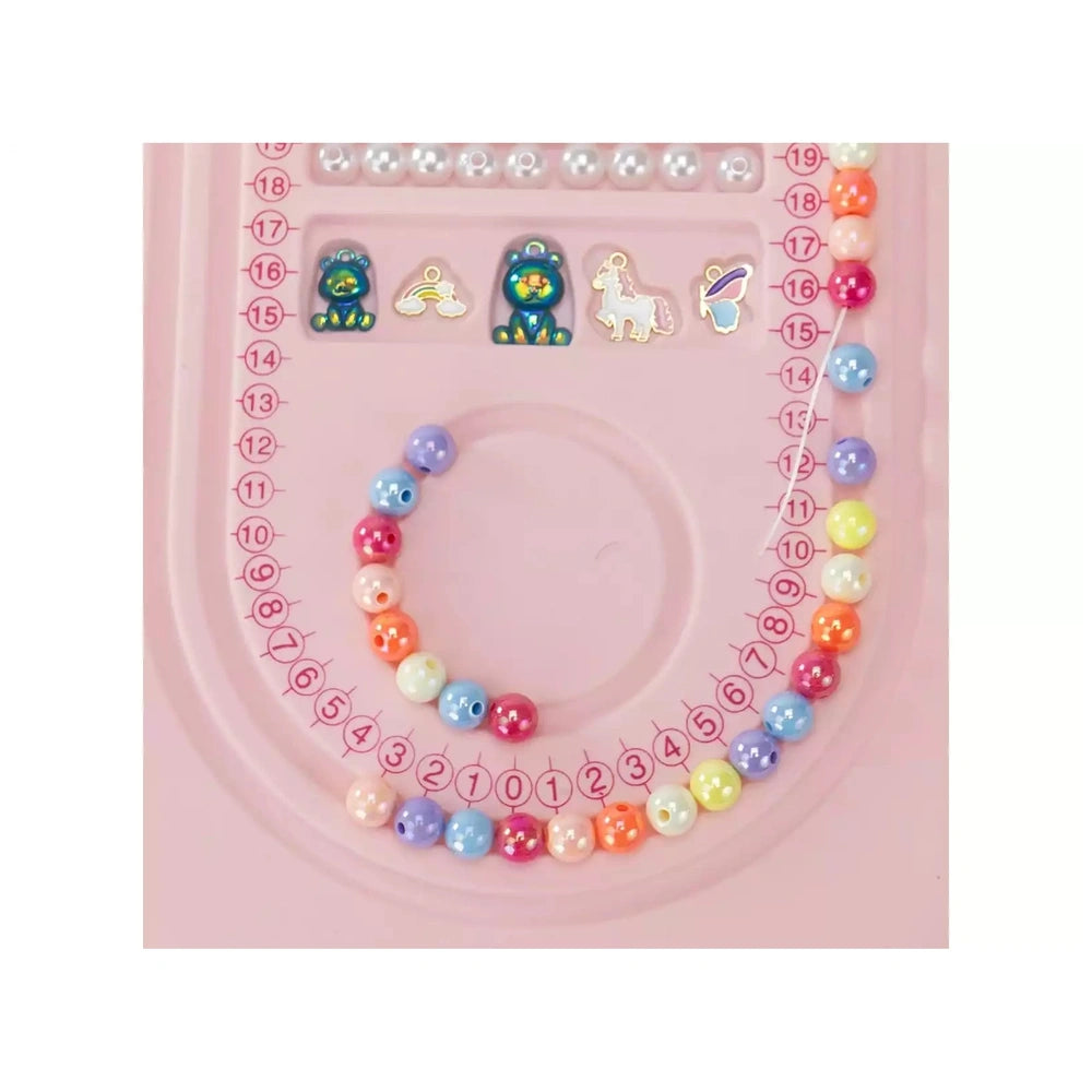 Jewel Design 600 Precious Beads bracelet in blue, pink, yellow, and white on a pink grid background with symbols.