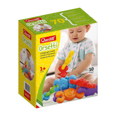 Quercetti Orsetti baby activity toys in colorful packaging featuring various glossy toy vehicles on a yellow, green, and whit