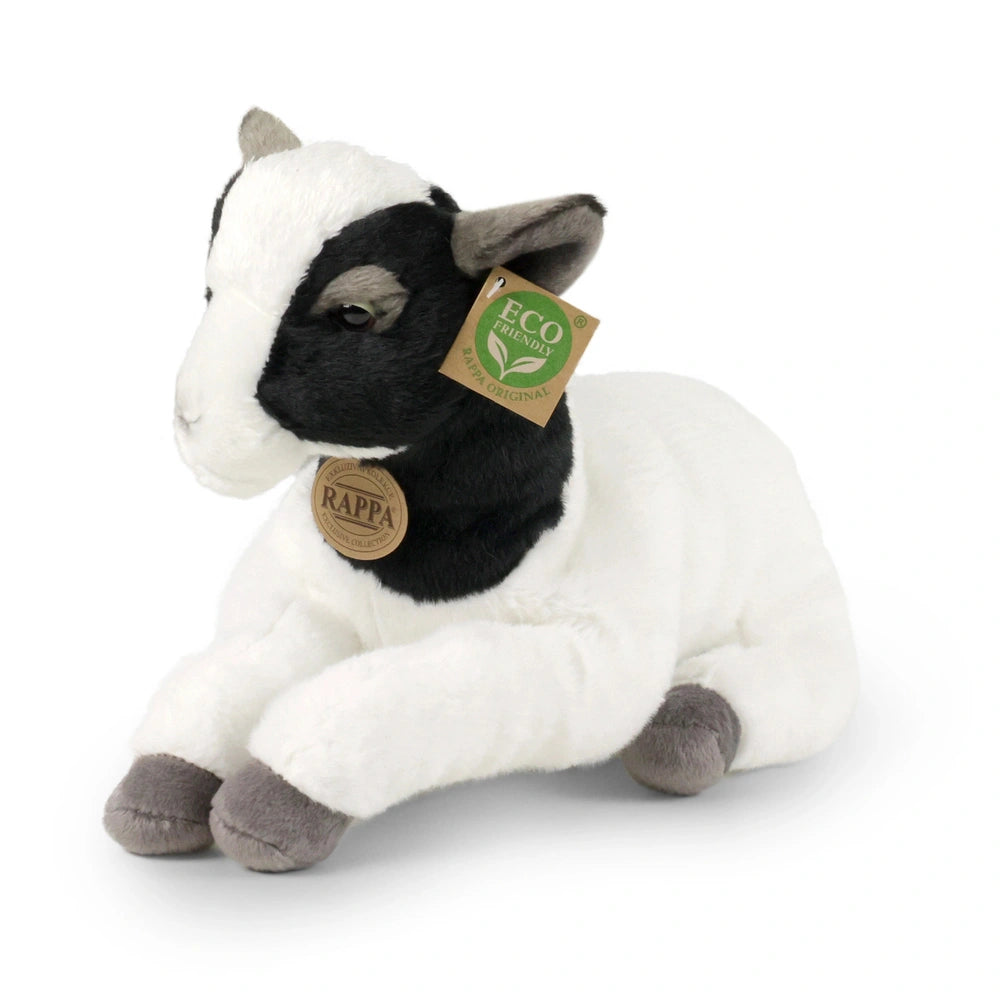 Plush goat with a white body and black markings, sitting on a smooth surface, featuring an eco-friendly tag.