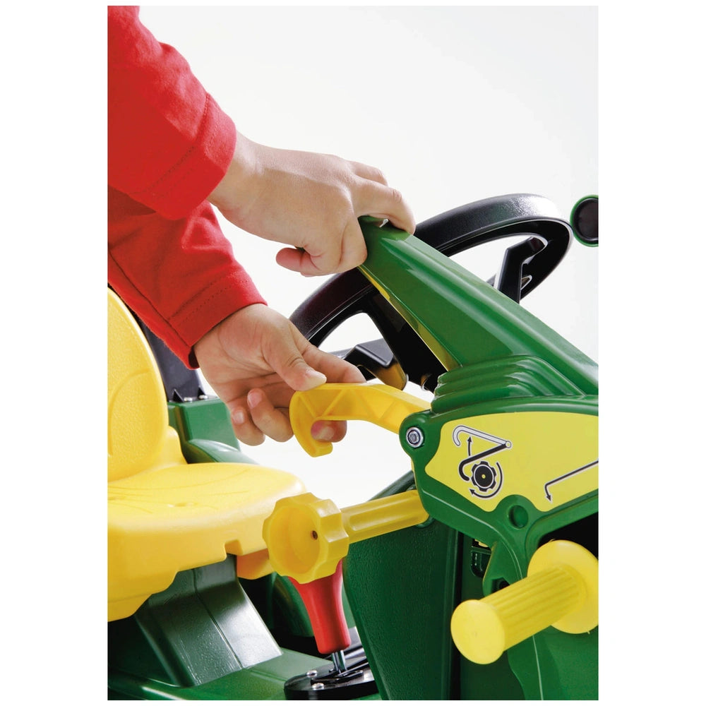 Rollyfarmtrac John Deere 7930 toy tractor with green and yellow design, operated by a person in a red shirt.