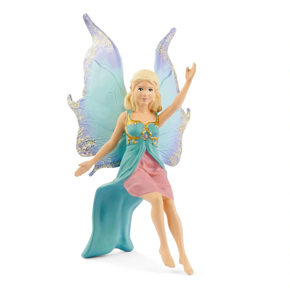 Fairy doll with long blonde hair in a blue and pink dress, posed dynamically with glittery wings against a light background.
