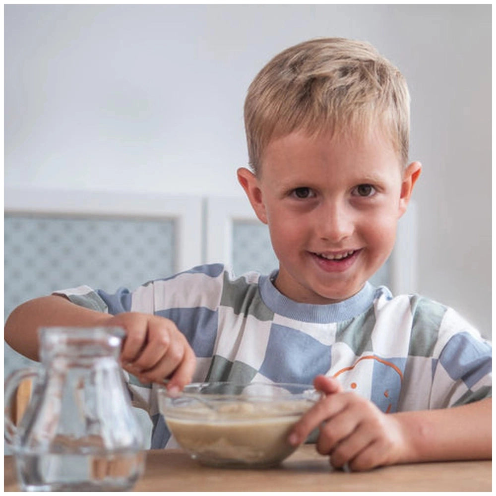 Teifoc water-soluble mortar is featured with a smiling boy enjoying a creamy substance at a wooden table.