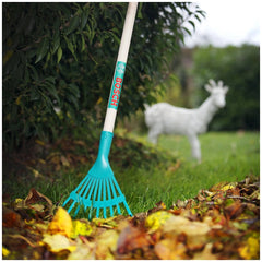 Theo Klein Bosch Garden rake in blue on green grass with brown and yellow leaves and a deer statue in the background.