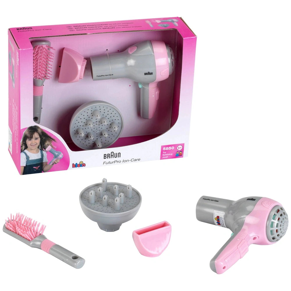 Theo Klein Braun hairdryer with pink nozzle and brush featuring pink handle and grey bristles, all in a glossy pink box.