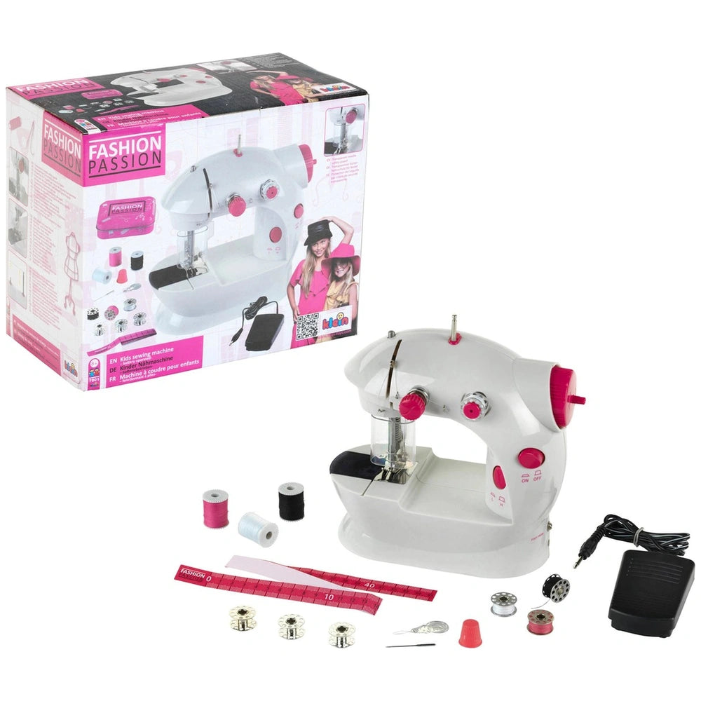 Theo Klein kids sewing machine in white and pink with multiple spools, needles, and bobbins for arts and crafts.