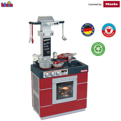 Theo Klein Miele kitchen compact oven in red metallic finish with multiple silver utensils and clear glass window.