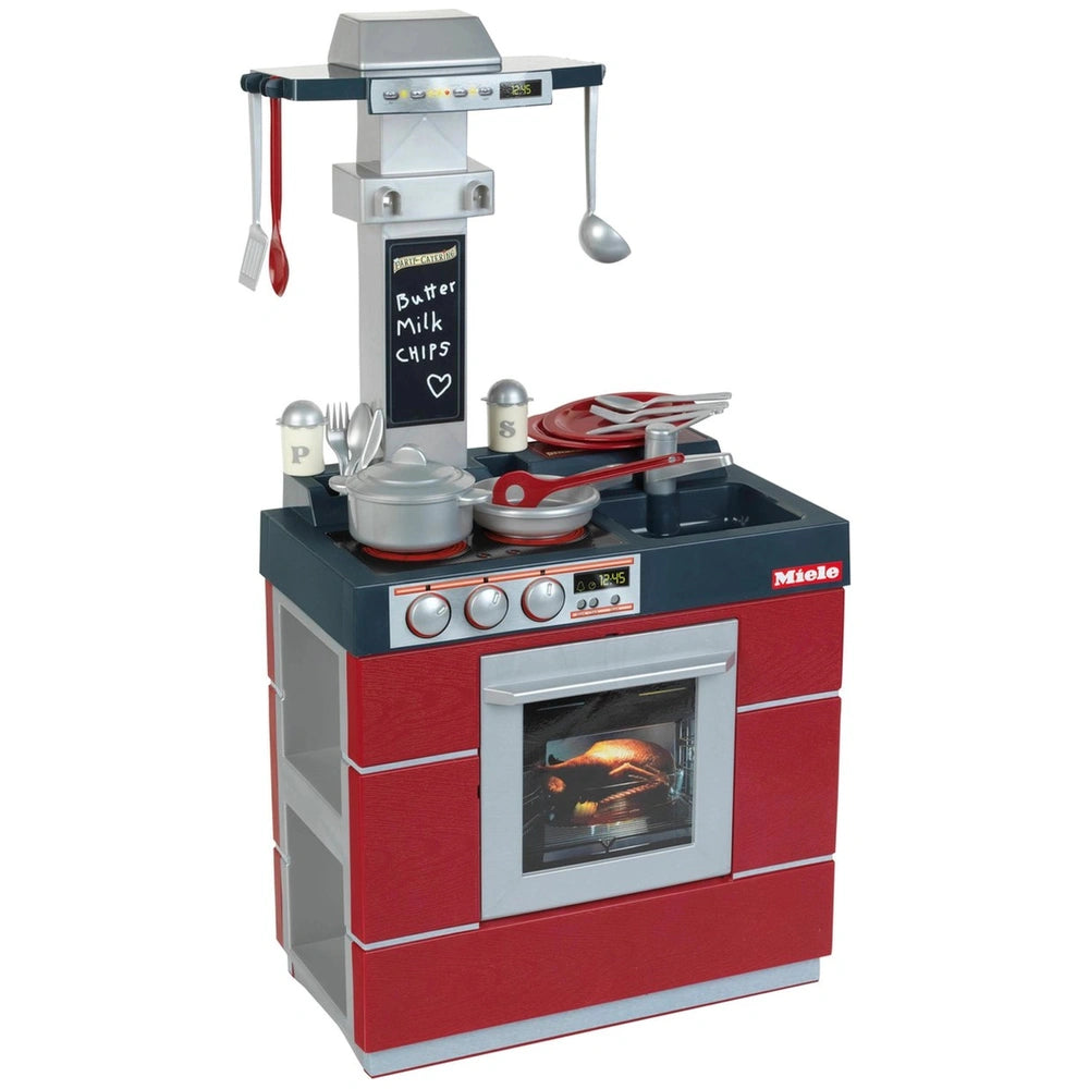 Theo Klein Miele Kitchen Compact in red metallic finish with silver utensils, featuring a clear glass oven window and knobs.